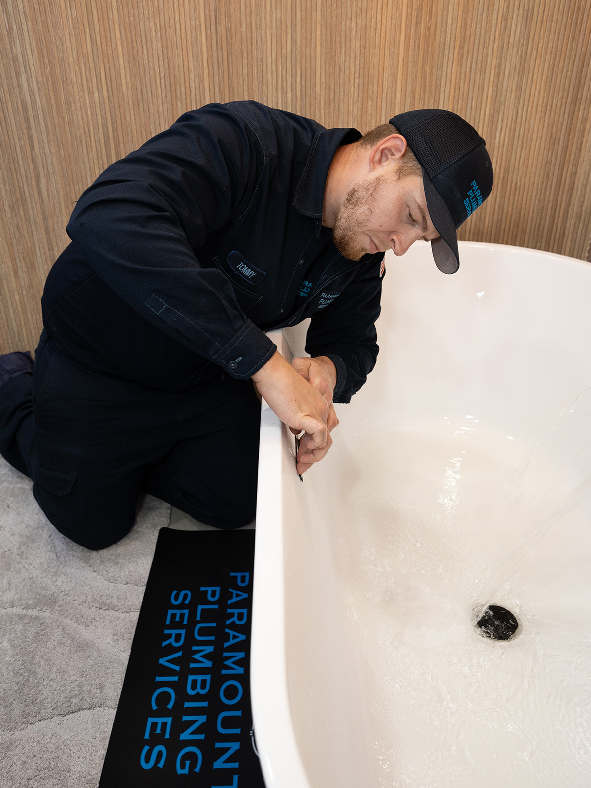 Paramount plumber examining bathtub drain