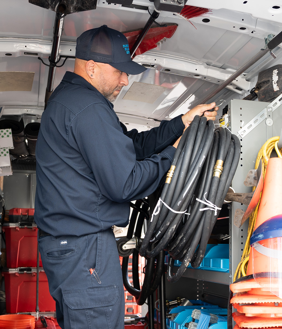 plumber holding a hydro jetting hose in his hand